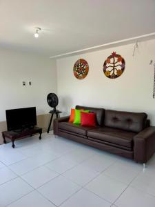 ein Wohnzimmer mit einem braunen Sofa und Wandplatten in der Unterkunft Flats Varandas Praia Bela - Apto 103 in Pitimbu
