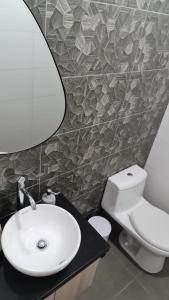 ein Badezimmer mit Waschbecken, Toilette und Spiegel in der Unterkunft Departamento Centrico Yanahuara Beaterio in Arequipa