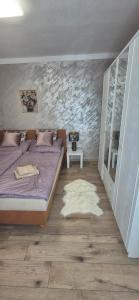 a bedroom with a purple bed and a white rug at Krkonošský apartmán DELUXE in Poniklá