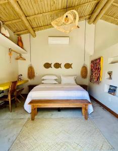 ein Schlafzimmer mit einem großen Bett und einem Tisch in der Unterkunft Casa Preguiça Corumbau in Corumbau