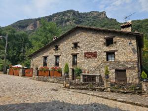 比盖特4LLARS的山前一座石头建筑，鲜花簇拥。