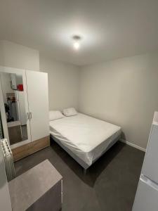 ein kleines Schlafzimmer mit einem Bett und einem Spiegel in der Unterkunft Apartment with terrace and barbecue Hyper center in Mâcon