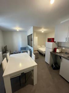 eine Küche mit einem Tisch und ein Zimmer mit einem Bett in der Unterkunft Apartment with terrace and barbecue Hyper center in Mâcon
