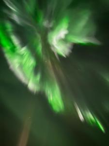 een afbeelding van het noorderlicht in de lucht bij Fjord & Flame in Tromsø