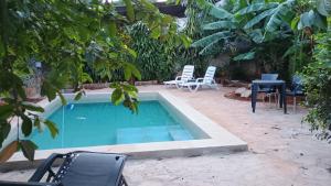 a pool with chairs and a table and trees at Villa Loma in Caacupé