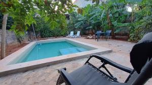 a swimming pool with a chair and a hammock next to it at Villa Loma in Caacupé