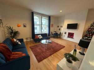 een woonkamer met een blauwe bank en een kerstboom bij The Athenaeum in Sunderland