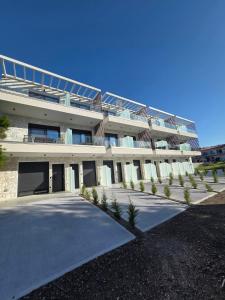 een groot gebouw met palmbomen ervoor bij Sunny Aparts in Polykhrono