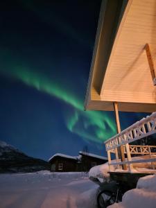 een observatiedek met het poollicht in de lucht bij Fjord & Flame in Tromsø