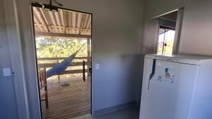 a kitchen with a refrigerator and a door to a porch at Recanto dos Pássaros in Palhoça +26 photos