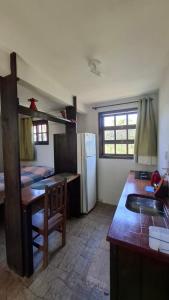 a kitchen with a sink and a refrigerator at Recanto dos Pássaros in Palhoça