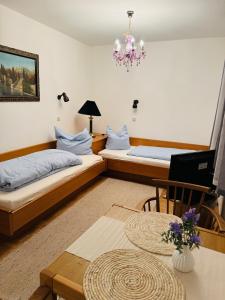 Habitación con 2 camas, mesa y lámpara de araña. en Ferienwohnung Nika, en Bad Reichenhall 8 fotos más