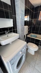 a bathroom with a washing machine and a toilet at Apartmani Green Olive in Šušanj +27 photos