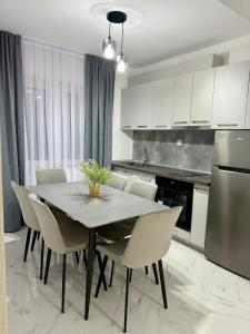 a kitchen with a table with chairs and a refrigerator at Comfort House Kocani in Kočani +10 photos