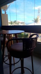 a table and chair in front of a window at Apartamento 2 quartos Mamelucos in Salvador