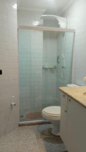 a bathroom with a toilet and a glass shower at Apartamento 2 quartos Mamelucos in Salvador