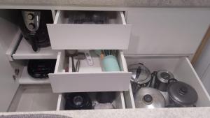 a cabinet with two white boxes and other kitchen utensils at Apartamento 2 quartos Mamelucos in Salvador +6 photos