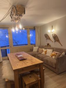una sala de estar con un sofá y una mesa en Le Cocon, en La Mongie