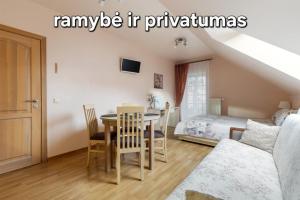a bedroom with a dining room table and a bed at Vila Liepa in Birštonas