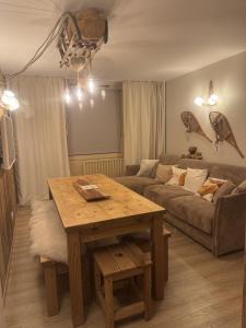una sala de estar con una mesa y un sofá en Le Cocon, en La Mongie 39 fotos más