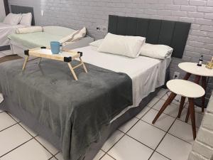 een kamer met een bed, een tafel en twee tafels bij Angra dos Reis Flat Suíte no Portogalo in Angra dos Reis +86 foto's