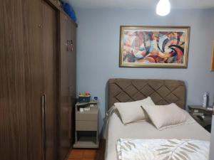 a bedroom with a bed and a painting on the wall at Família Jardim in São Gabriel
