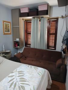 a living room with a couch and some windows at Família Jardim in São Gabriel