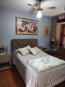 a bedroom with a bed with a ceiling fan at Família Jardim in São Gabriel