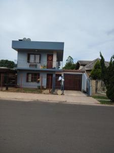 a blue house with a fence in front of it at Família Jardim in São Gabriel