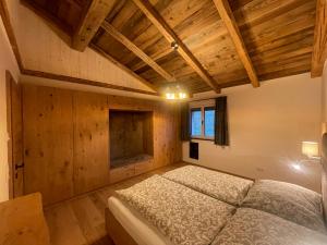 een slaapkamer met een bed in een kamer met houten plafonds bij Ferienwohnung Unterdürmoos in Annaberg im Lammertal