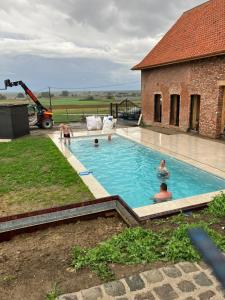a group of people in a swimming pool next to a building at Tjusteplekske in Heuvelland