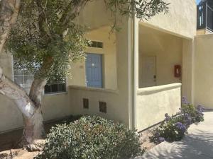 a building with a tree and a blue door at The Mahogany Shore in Oceano +3 photos