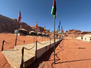 a fence with flags on it in the desert at Desert Nights Camp in Wadi Rum +11 photos