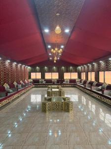 a large room with a pool with couches and chairs at Desert Nights Camp in Wadi Rum