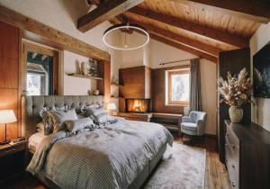 une chambre avec un grand lit et une chaise dans l'établissement Elegance Home, à Cortina dʼAmpezzo