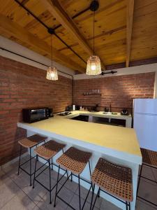 a kitchen with a large counter with stools in it at Amambay in Puerto Bossetti