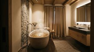 une salle de bains avec une grande baignoire et un lavabo dans l'établissement Elegance Home, à Cortina dʼAmpezzo 19 autres photos