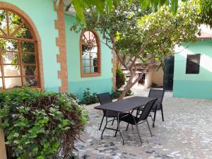 een tafel en stoelen voor een gebouw bij Afonta's Greenhouse Retreat - A Fully Furnished Four Bedroom Bungalow Per Night For The Price Shown And Includes The Use Of A Washing Machine For Free in Daranka