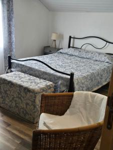 una camera con letto, sedia e ottomana di Rustica Ocean View House a Bretanha