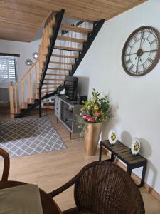 un soggiorno con scala e orologio sul muro di Rustica Ocean View House a Bretanha