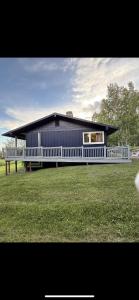 una casa blu con una staccionata bianca in un campo di Luxury Northern Light Oasis a Fairbanks