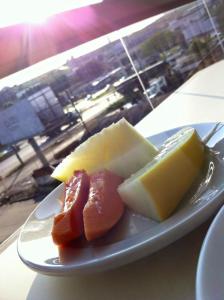 un plato de queso y fruta en una mesa en Hotel Zagonel, en Chapecó