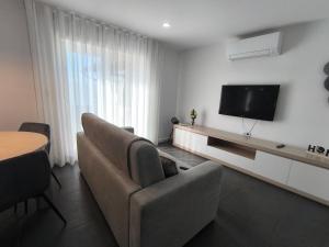 a living room with a couch and a flat screen tv at Casa de Campelo in Vila Nova de Cerveira