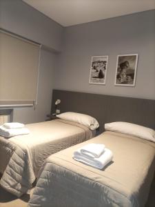 圣胡安Apart America的一间有两张床和毛巾的房间