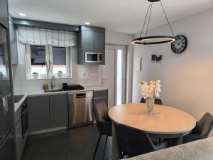 a kitchen with a table with a vase of flowers on it at Casa de Campelo in Vila Nova de Cerveira