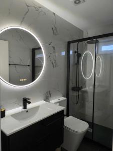a bathroom with a toilet and a sink and a mirror at Casa de Campelo in Vila Nova de Cerveira