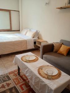 een woonkamer met een bed en een tafel met borden erop bij Paseo Aldrey in Mar del Plata