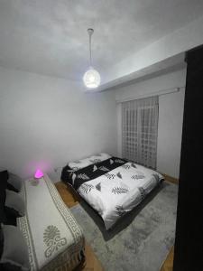 una camera da letto con un letto e una sedia di Bleon Apartment a Prizren Altre 3 foto