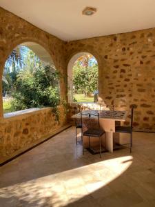 a dining room with a table and two windows at Appartement Domaine Du Soleil Hammamet 