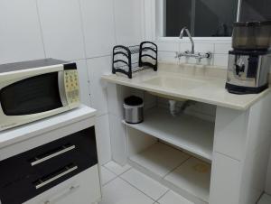 a kitchen with a sink and a microwave at Cantinho do Sossego in Indaiatuba
